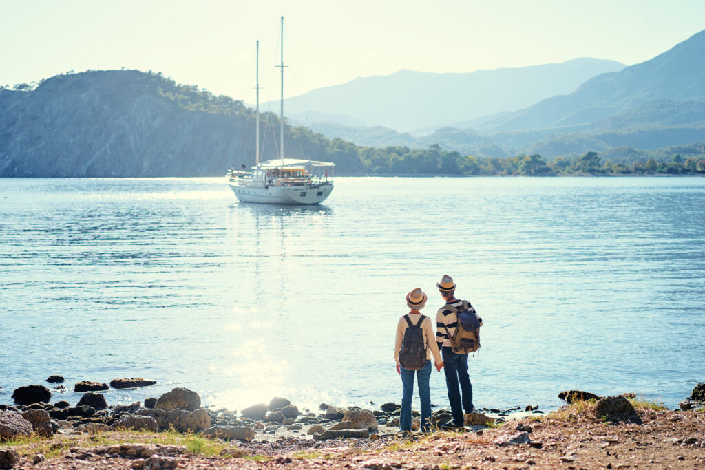 Travel and tourism. Senior family couple standing together on Mediterranean sea beach.