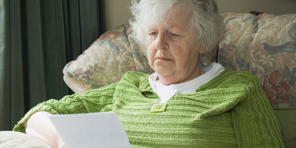 Senior woman reading a Medicare-related letter while reviewing her retirement healthcare information